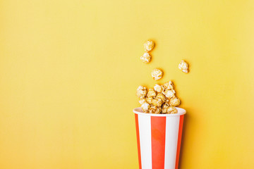 Sweet caramel popcorn in paper striped white red cup