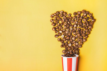 Sweet chocolate popcorn in paper striped white red cup