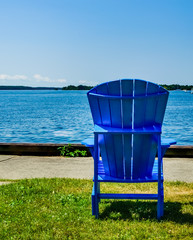 Blue adirondack chair  overlooking the water's edge