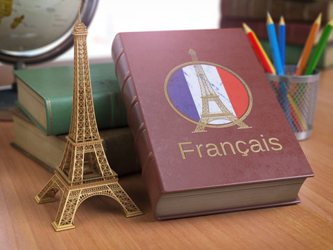 Learn and studiyng French concept. Book with  French flag and Eiffel tower on the table.