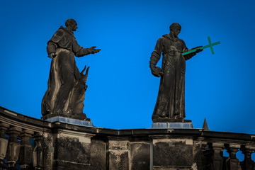 Obraz premium Detail zwei verwitterte Heilige Statuen auf dem Kirchendach in Dresden