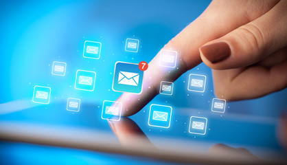 Female hands touching tablet with e-mail icons 