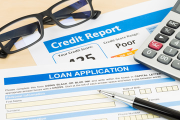 Loan application form poor credit score with calculator, glasses, and pen