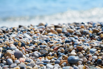 Pebble beach with blurred sea water on a background. 