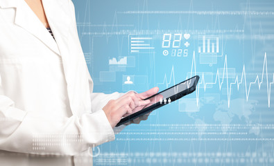 Female doctor holding tablet with blue background and heart related charts 