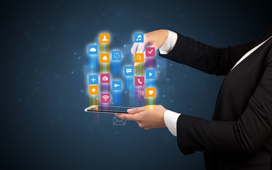 Female elegant hand holding tablet with colourful application icons