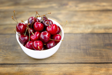 Fresh cherry on plate on wooden background. fresh ripe cherries. sweet cherries.