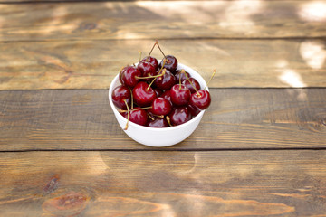 Fresh cherry on plate on wooden background. fresh ripe cherries. sweet cherries.