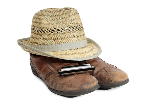 Harmonica and straw hat on a white background