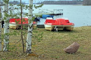 Pier, pontoon on the waterside of the lake Seliger with catamarans and boats with forest on the...
