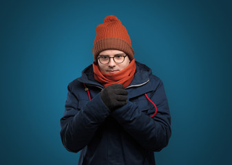 Handsome young boy freezing in warm clothing with copy space