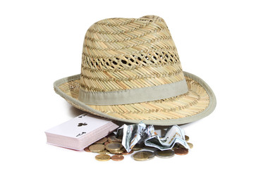 Straw hat and money with playing cards on a white background
