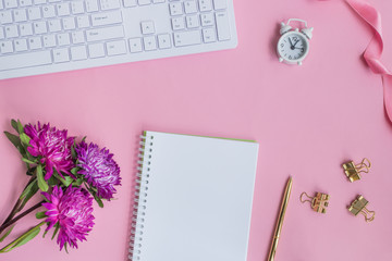 Blogger or freelancer workspace with notebook and pink flowers