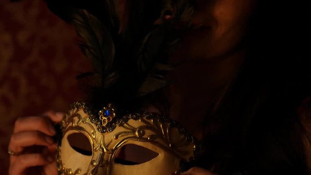 mysterious woman holding gold venetian mask, night, dusk
