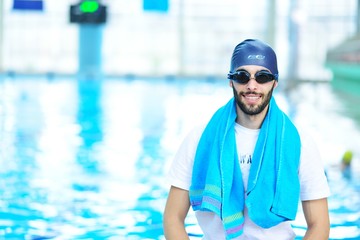 Swimming coach standing by the pool at the leisure center