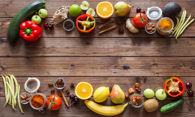 Fototapeta na wymiar Healthy food, clean food selection: fruits, vegetables, seeds, spices on brown boards with free space in the middle
