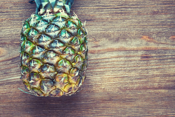 Delicious ripe pineapple on a wooden background.