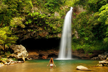 Fototapeta premium Młoda kobieta w bikini stojąca przy wodospadach Lower Tavoro w Parku Narodowym Bouma na wyspie Taveuni na Fidżi