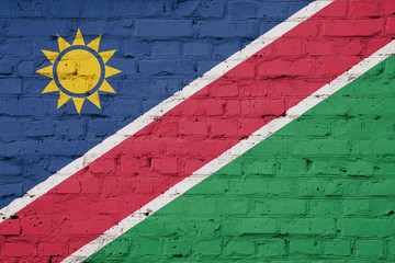 Texture of a flag of Namibia on a pink brick wall.
