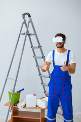 Man with VR glasses gluing wallpaper