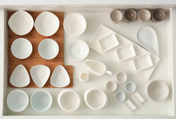 Set of ceramic tableware in kitchen drawer