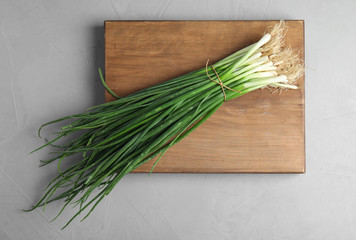 Fresh green onion on wooden board, top view