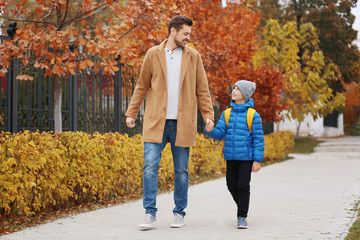 Cute little boy going to school with his father