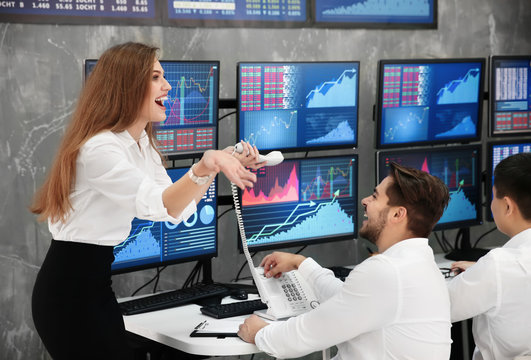 Excited stock traders working in office