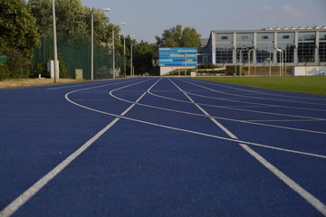 Blue outdoor stadium running track with white dividing lines