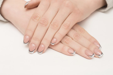 Hands with manicured nails covered with pink nail polish on fur background