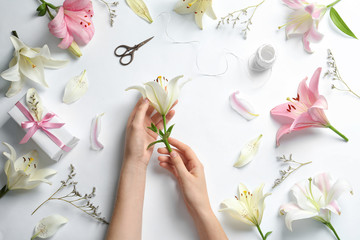 Naklejka na ściany i meble Woman with beautiful lily flower on white background, top view