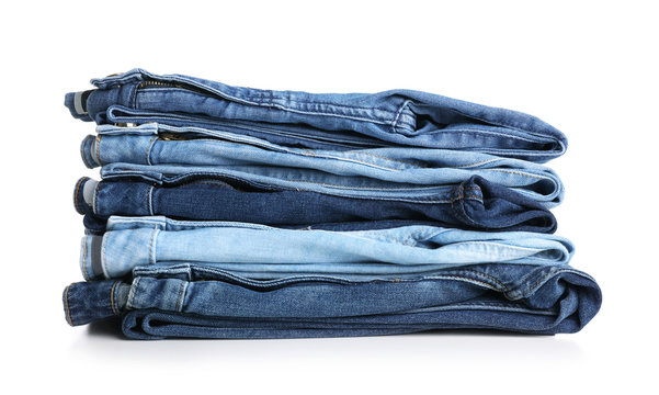 Stack of stylish jeans on white background