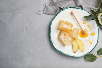 Flat lay composition with honey, sliced apple, dipper and honeycombs on light background