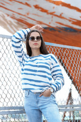 Young hipster woman in stylish jeans on pier