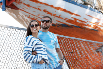 Young hipster couple in stylish jeans on pier