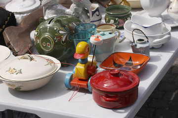 Weekend flea market in the city center on a sunny day. Market booth with objects for sale and...