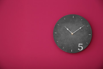 Stylish clock on color wall. Time concept