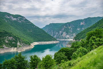 Obraz na płótnie Canvas An unusual mountain lake with turquoise water is located in a canyon among the high mountains.