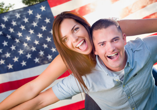 Military Couple Piggy Riding In Front of American Flag