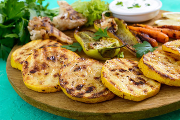 Grilled vegetables, fresh herbs, sauce on a wooden tray. Healthy food. A delicious appetizer.
