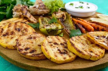Grilled vegetables, fresh herbs, sauce on a wooden tray. Healthy food. A delicious appetizer.