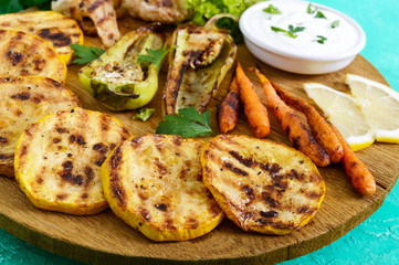 Grilled vegetables, fresh herbs, sauce on a wooden tray. Healthy food. A delicious appetizer.
