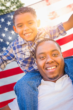 African American Father and Mixed Race Son Piggy Back with American Flag