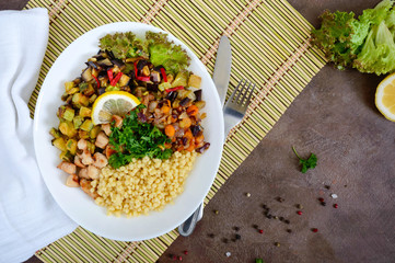 Delicious oriental salad tabbouleh. Couscous with fried vegetables and chicken on a white plate. Traditional Lebanese appetizer.