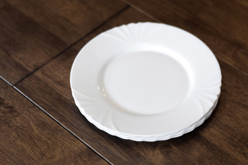 Empty plates on a wooden table closeup