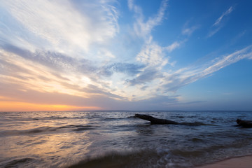 Obraz premium morning dawn log on the shore / calm water river near the city