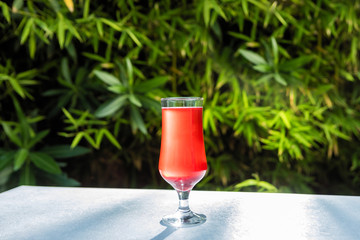Red cocktail with green background