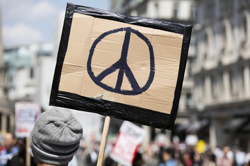 A person holds a peace sign banner at a protest