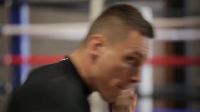 Strong man boxing using punch sake in gym, sunlight, close-up.
