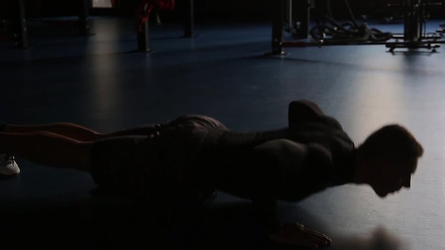 Man doing push-ups in gym, blue background